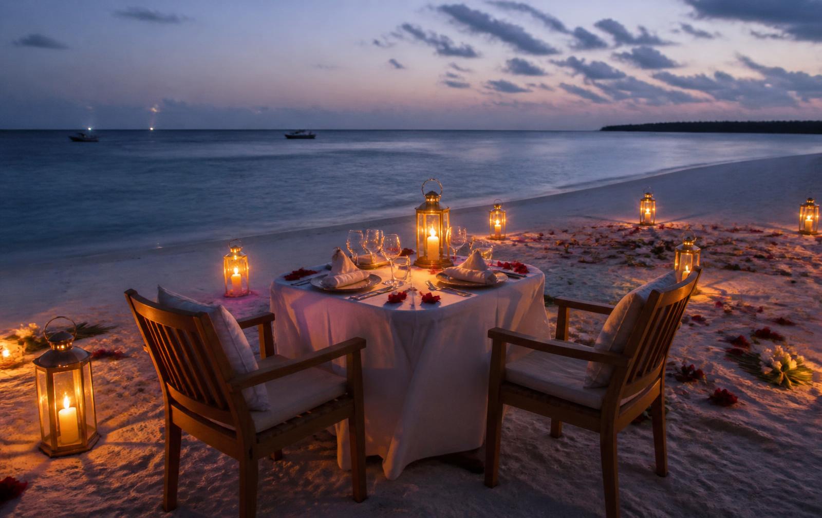 Candlelit dinner table for two on a Zanzibar beach at dusk