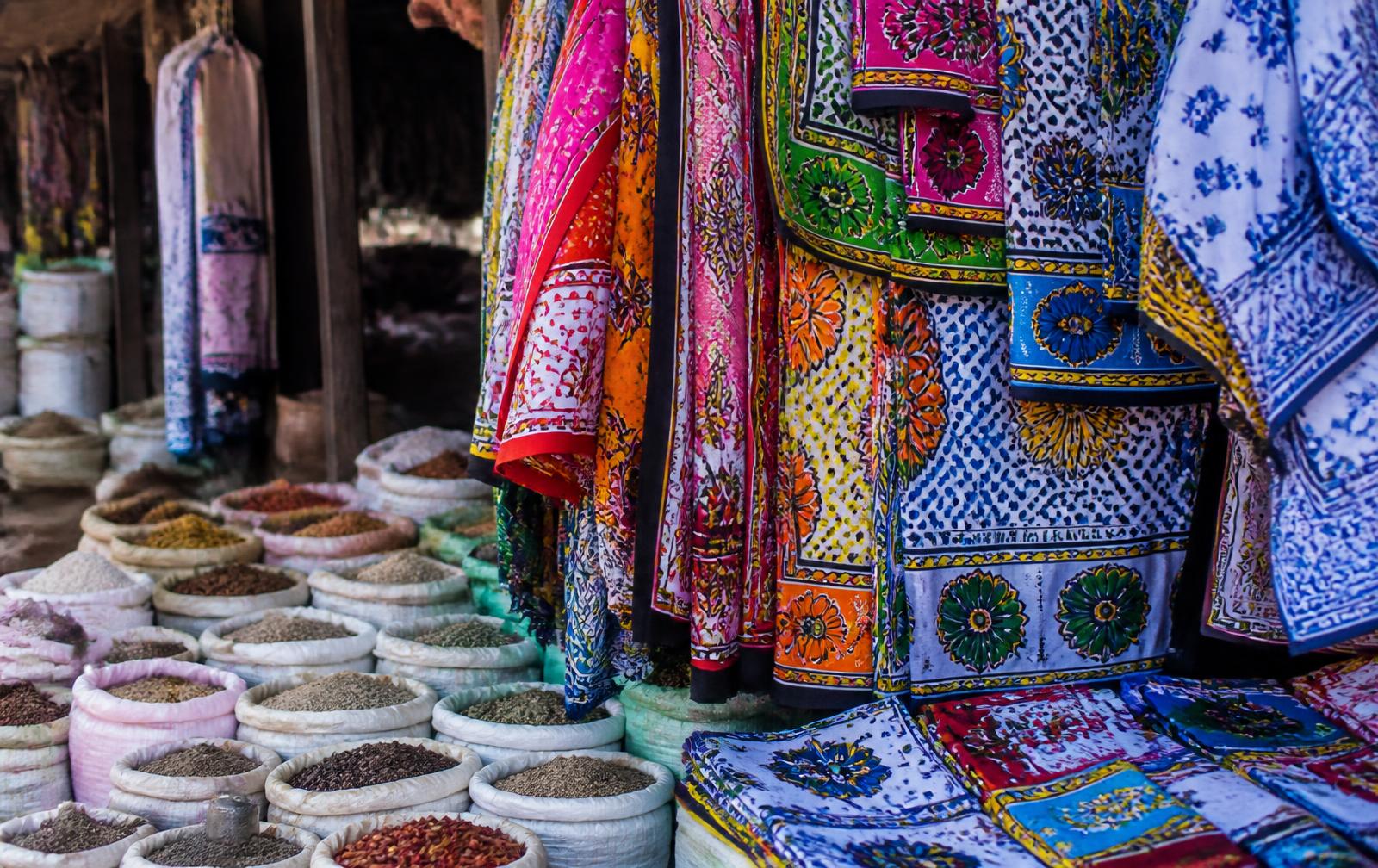 Kanga fabrics and spice sacks at a Zanzibar market stall