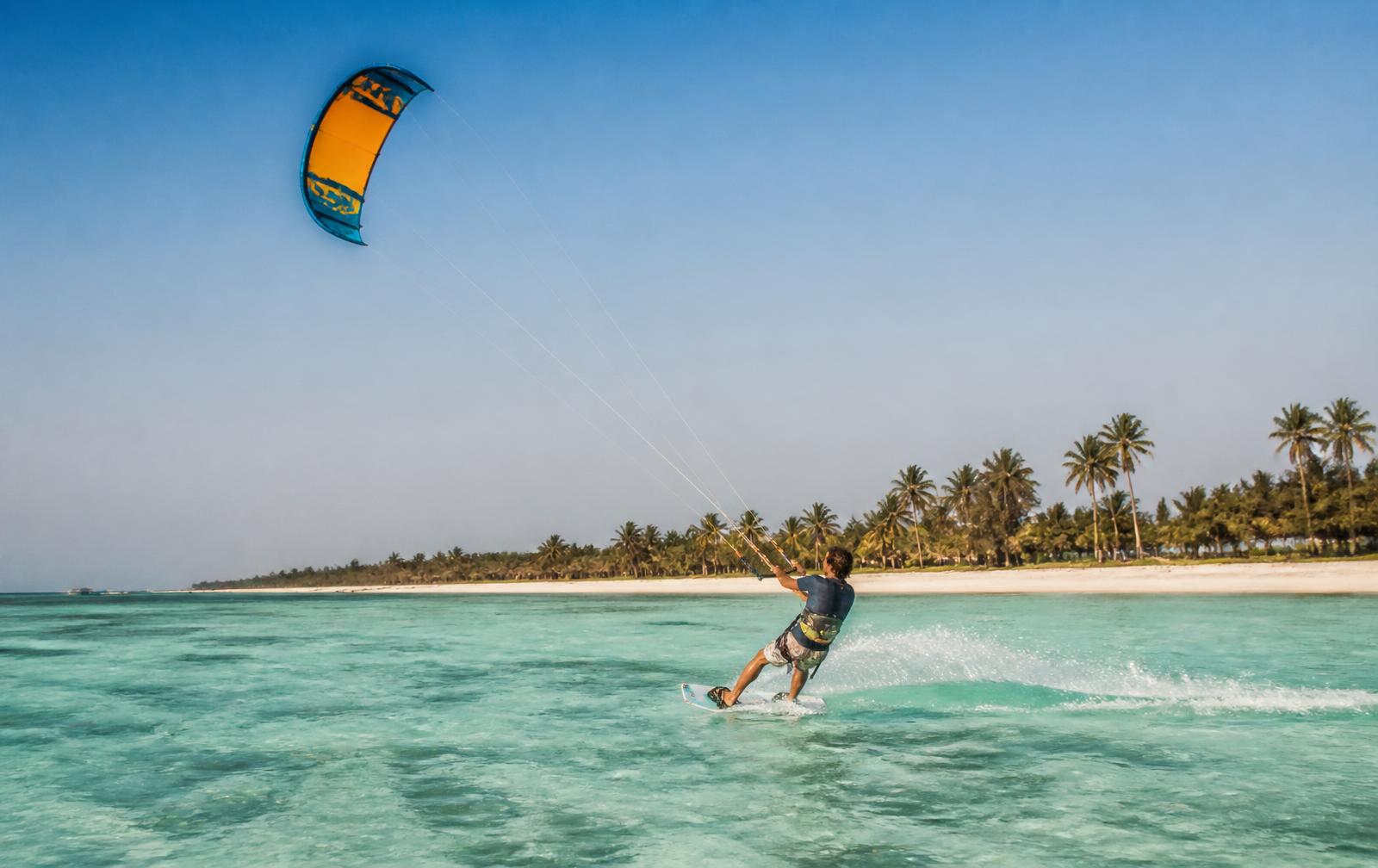 Kitesurfer riding a shallow turquoise lagoon on the Zanzibar coast