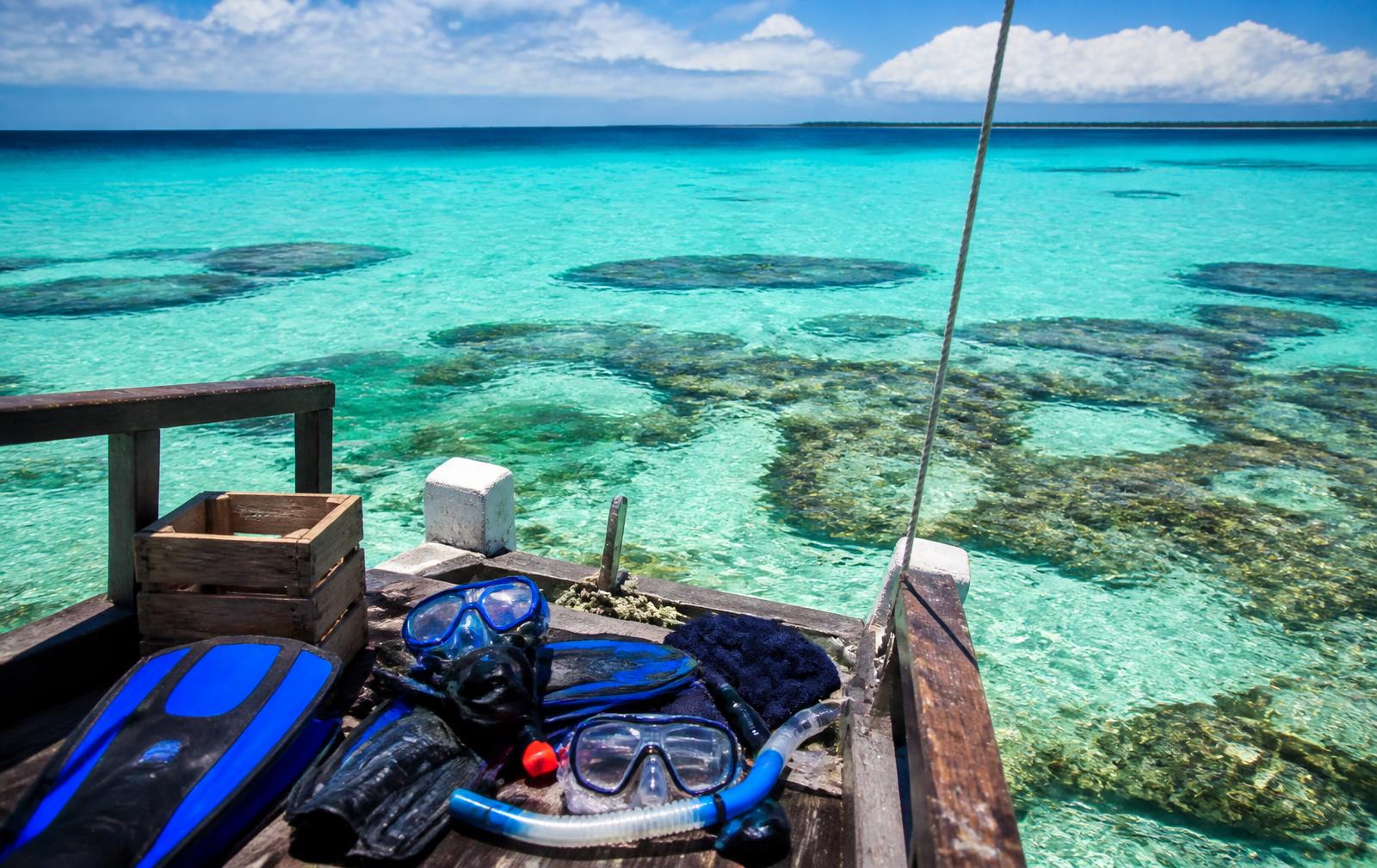 Snorkelling gear on a wooden excursion boat above a Zanzibar coral reef