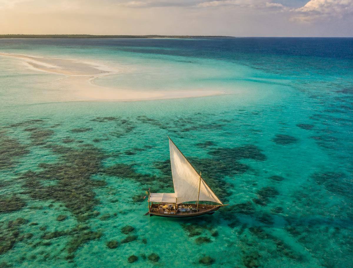 Traditional dhow boat on the turquoise water near Mnemba Atoll, Zanzibar