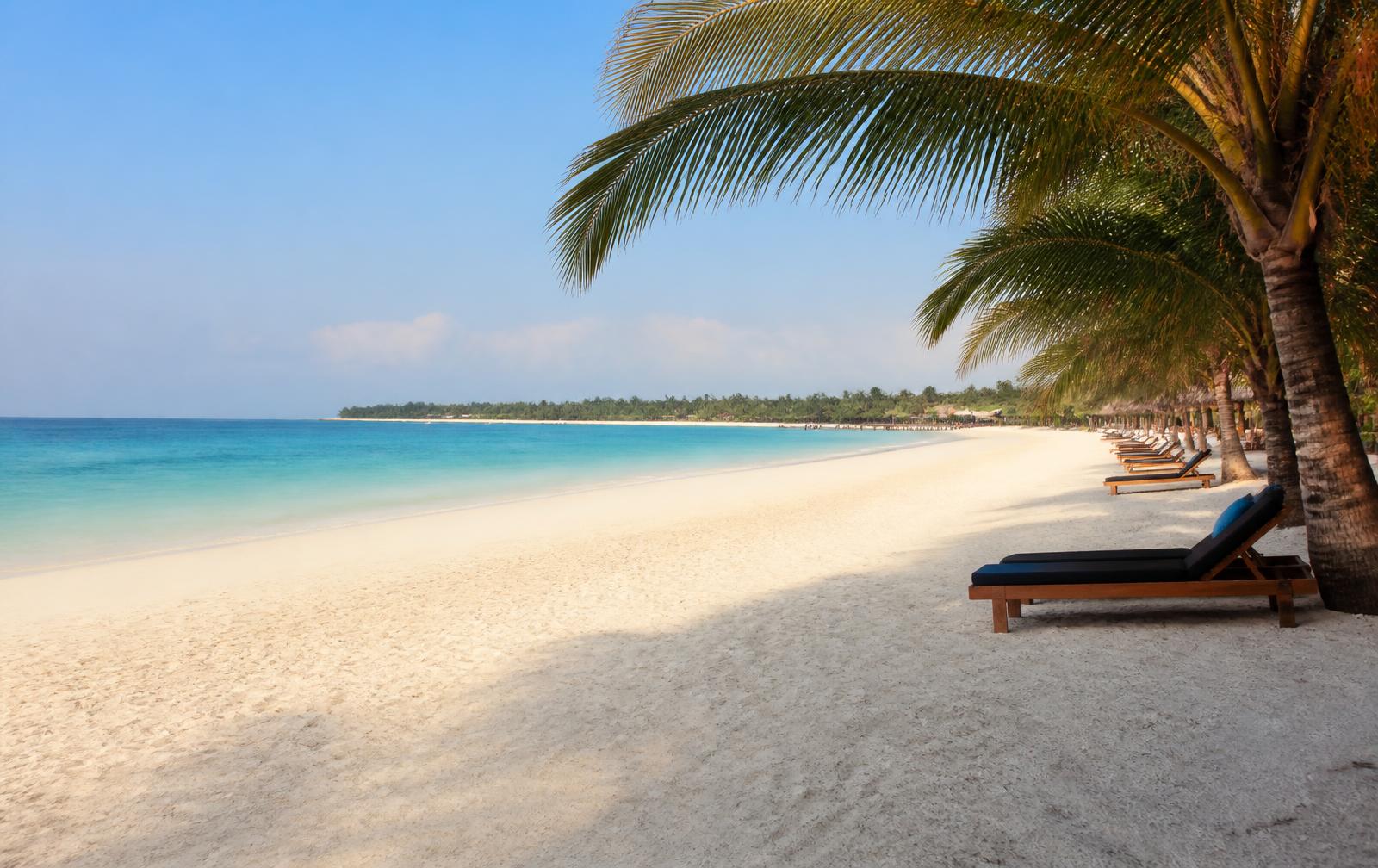 Wide white sand beach at Kendwa, Zanzibar, with palm shade and turquoise water