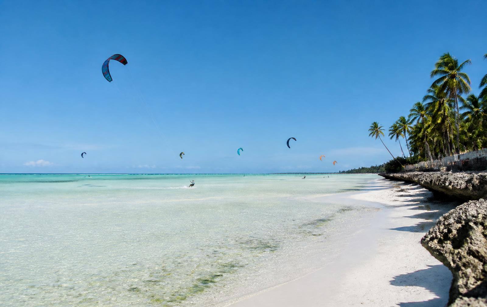 Kitesurfers on the shallow turquoise lagoon of Paje beach, Zanzibar
